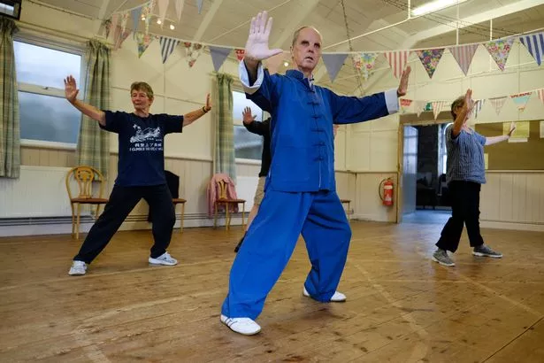 Sheila Mitchell, Dave Ireland and Lisa Williams practise Tai Chi under the guidance of their teacher Charlie Schwab in the Praze-an-Beeble village institute