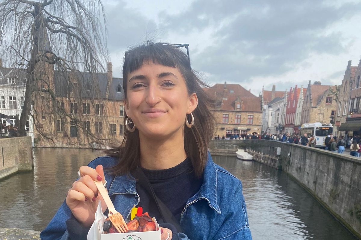 A young woman wearing a denim jacket enjoying some street food