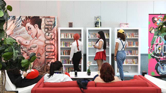 An Anime Expo photo shows attendees browsing a manga shelf