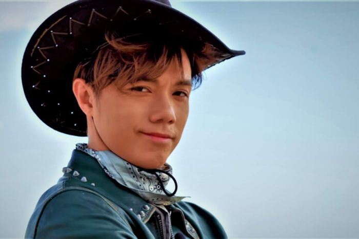 Hins Cheung A man smiles at the camera in a cowboy hat