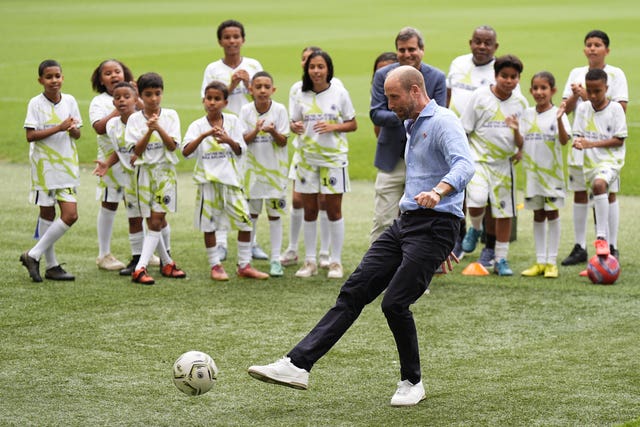 The Prince of Wales takes a penalty at a community football event at the Maracana Stadium