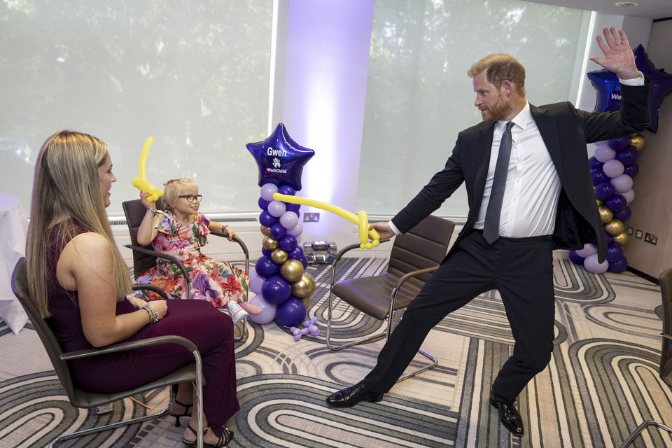 Harry play fights using swords made from modelling balloons with nine-year-old Gwen Foster at the annual WellChild Awards 2025 (Aaron Chown/PA)