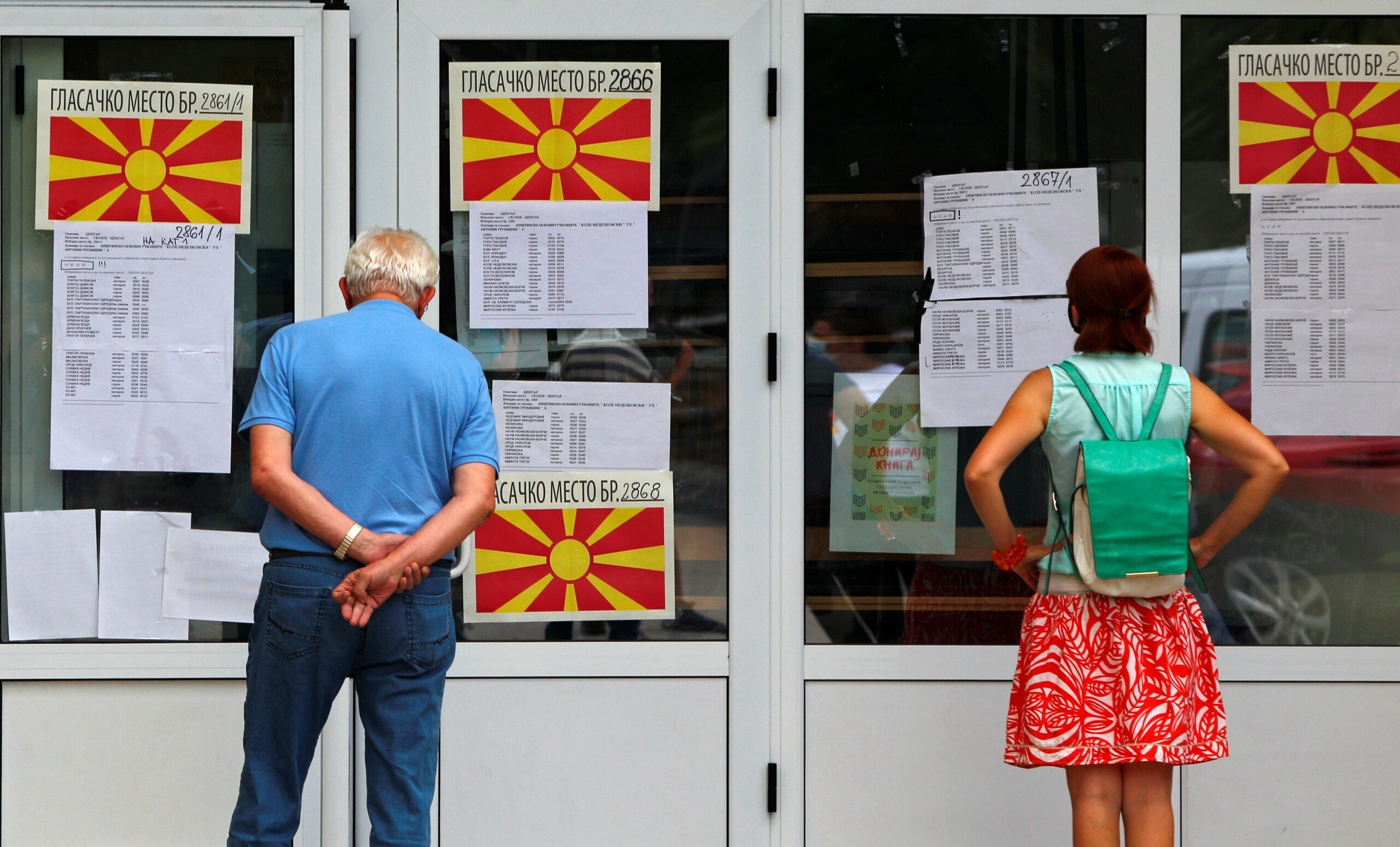 people looking at vote information in a window