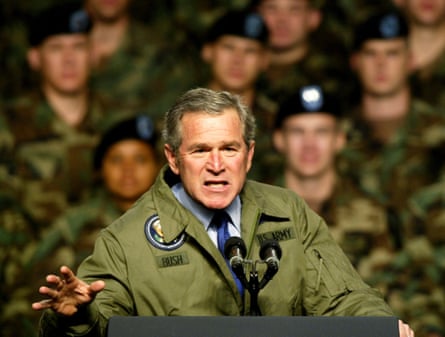 George W Bush speaking at a lectern with part of his audience of US soldiers visible behind him