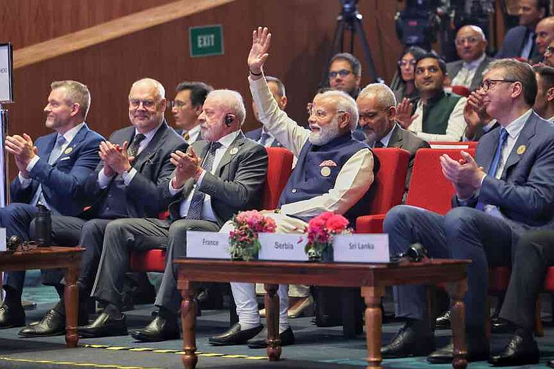 In this photo provided by Indian Prime Minister's Office, lndia's Prime Minister Narendra Modi, center, raises his hand in acknowledgment as other foreign dignitaries clap during the AI Summit in New Delhi, India, Thursday, Feb. 19, 2026. (Indian Prime Minister's Office via AP)