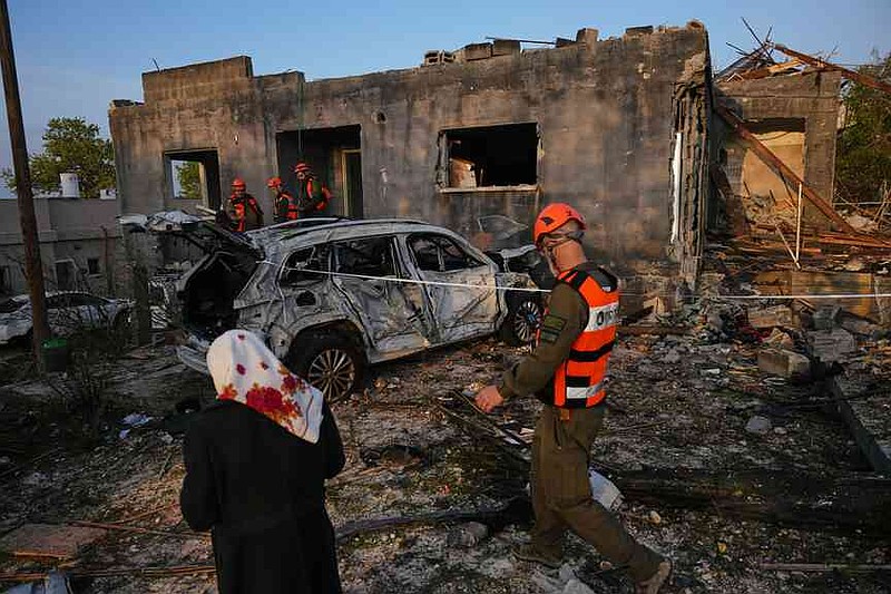 Residents and officers from Israel's Home Front Command inspect a house destroyed by an Iranian missile strike in Zarzir, northern Israel, Friday, March 13, 2026. (AP Photo/Ariel Schalit)