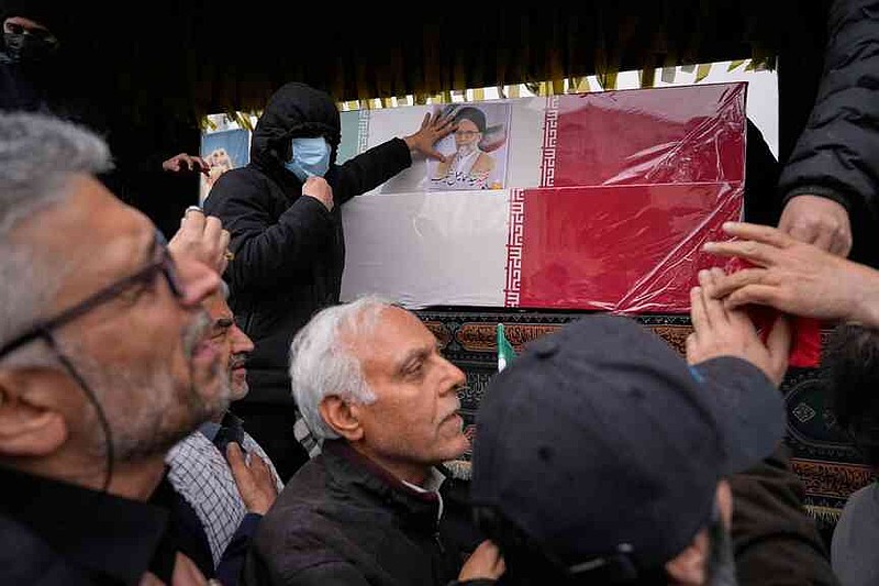Iranians reach toward the coffins as they follow the funeral procession of Iran's intelligence minister Esmail Khatib and, according to Iranian officials, his wife and daughter, in Tehran, Iran, Friday, March 20, 2026. (AP Photo/Vahid Salemi)