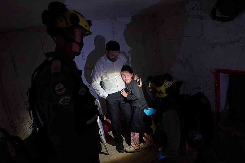 A young girl is comforted by her father and Israeli soldiers as they take cover in a bomb shelter during air raid sirens warning of incoming Iranian missile strikes in Bnei Brak, Israel, Wednesday, April 1, 2026. (AP Photo/Oded Balilty)