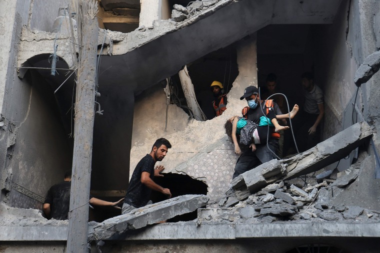 A Palestinian civil defense member carries a child killed in an Israeli bombardment in Khan Yunis, southern Gaza Strip, on Oct. 19, 2023.