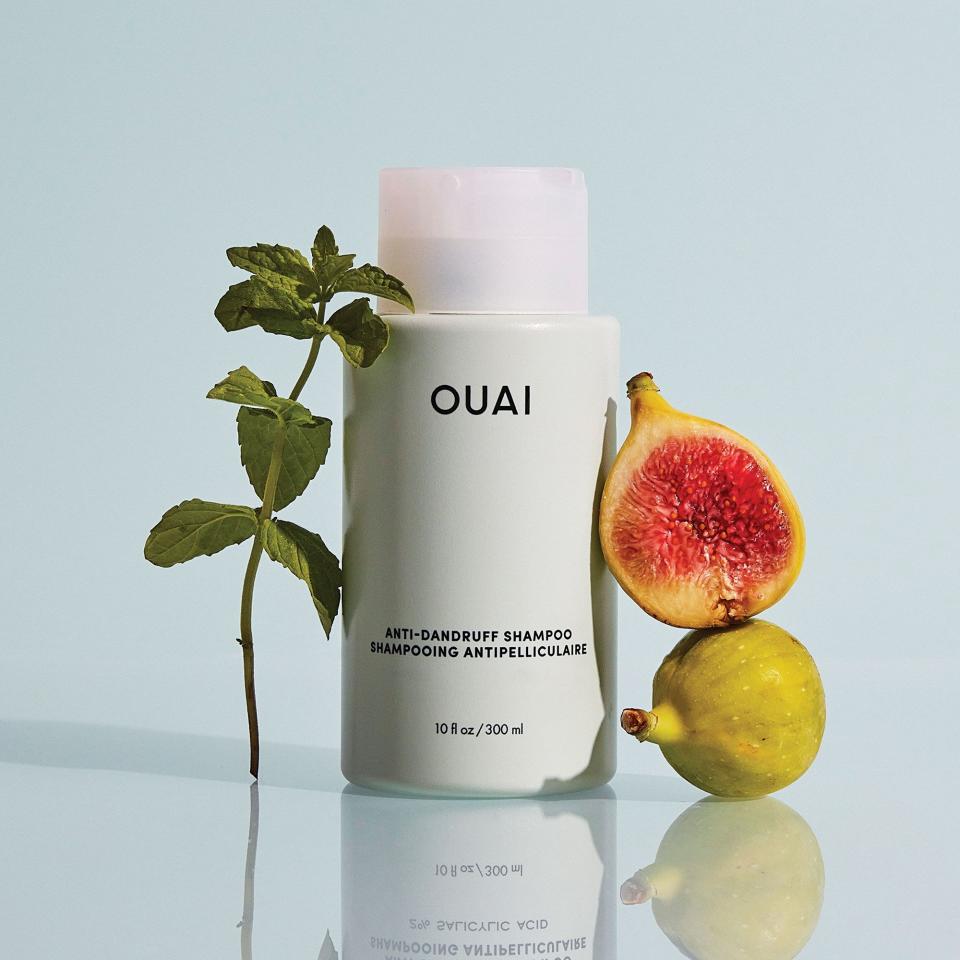 Ouai Anti-Dandruff Shampoo with passionfruit and a stalk of mint leave.