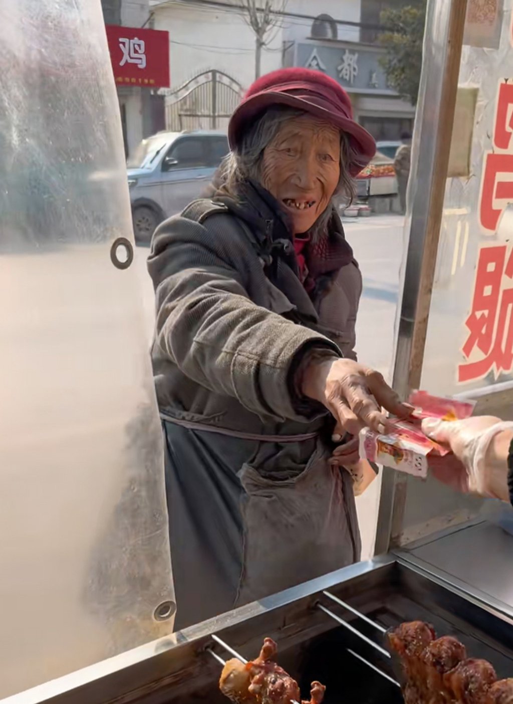 The elderly woman hands her “hell money” through the window of the food stall. Photo: Douyin The elderly woman hands her “hell money” through the window of the food stall. Photo: Douyin