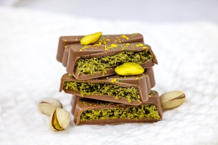 A closeup of a Dubai chocolate bar with green kadayif and pistachio.