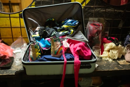 Brightly coloured clothes spill out of an open suitcase