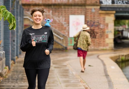 A smiling Lucy goes for a run with Stitch on her shoulder.