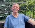 Chris Weston, in a T-shirt, sits next to a metal fence, smiling