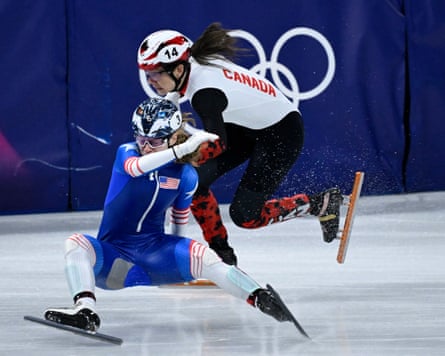 Canada’s Courtney Sarault skates past the United States’s Corinne Stoddard as she crashes in the short track speed skating mixed team relay semi-final at the 2026 Winter Olympics