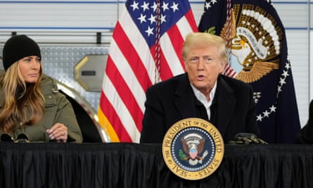 A man speaks at a podium next to a woman who is Melania Trump