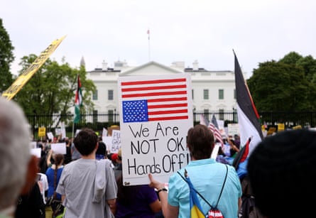 crowd of people hold signs in protest