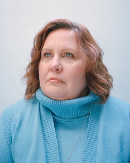 Portrait of Christine Dawood. She has mid-length light brown hair and is wearing a light blue polo neck with matching cardigan