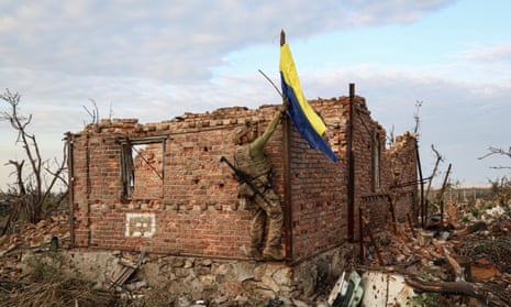 A Ukrainian commander raises the national flag in the frontline village of Andriivka on Saturday