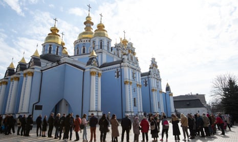 Orthodox priests bless believers and consecrate willow branches with holy water on Palm Sunday near St. Michael's Church in Kyiv.
