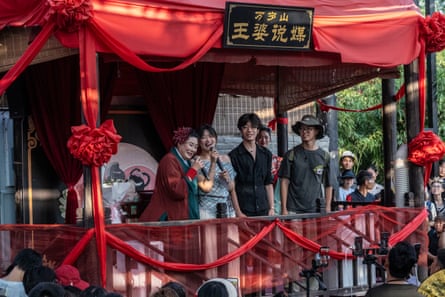 Zhao Mei as Granny Wang on stage with a young woman and two young men