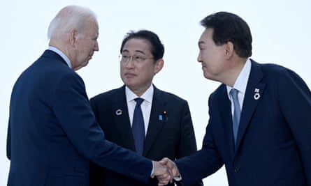 Joe Biden shakes hands with Yoon Suk Yeol as Fumio Kishida looks on
