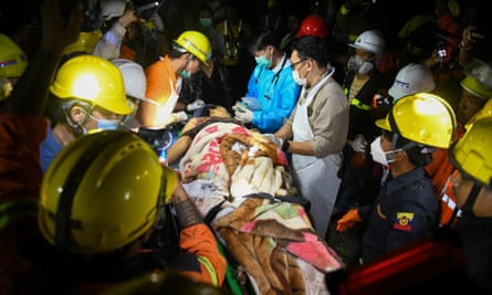 Doctors and medics teams treat a woman laid under a blanket