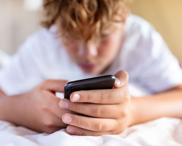 teenage boy is using smartphone at home in bed teenage boy is using smartphone at home in bed