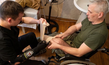 Dr. Alexis Cholas, left, bandages an amputated limb of Serhiy Hohdan, Ukrainian soldier at the hospital's rehabilitation center in Kyiv, Ukraine.