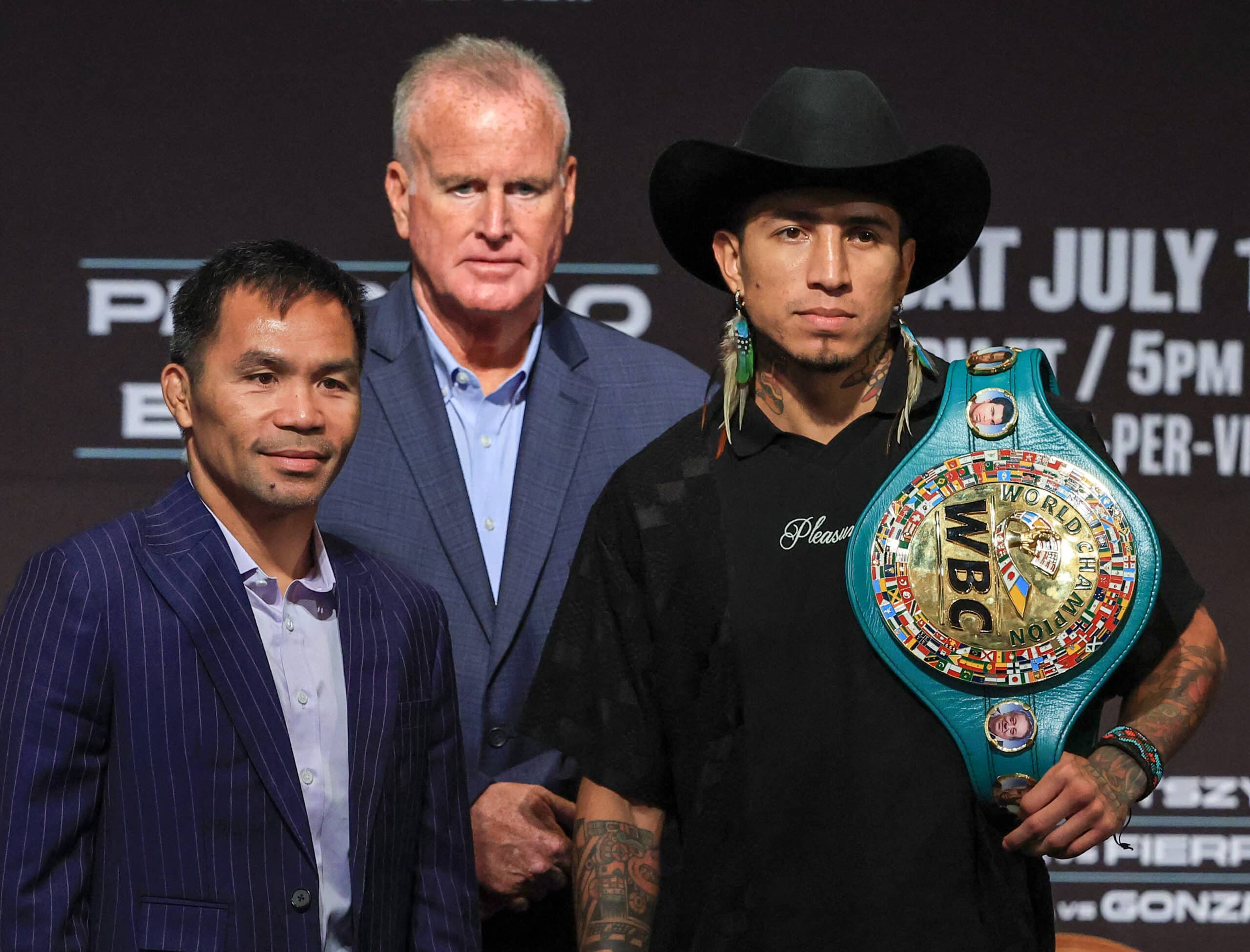 TGB Promotions President Tom Brown (C) looks on as Manny Pacquiao (L) and WBC welterweight champion Mario Barrios (R) pose during their news conference at MGM Grand Hotel &; Casino on July 16, 2025 in Las Vegas, Nevada.