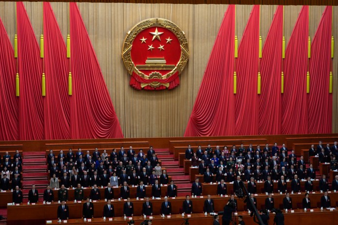 Chinese leaders stand for the national anthem at the National People's Congress