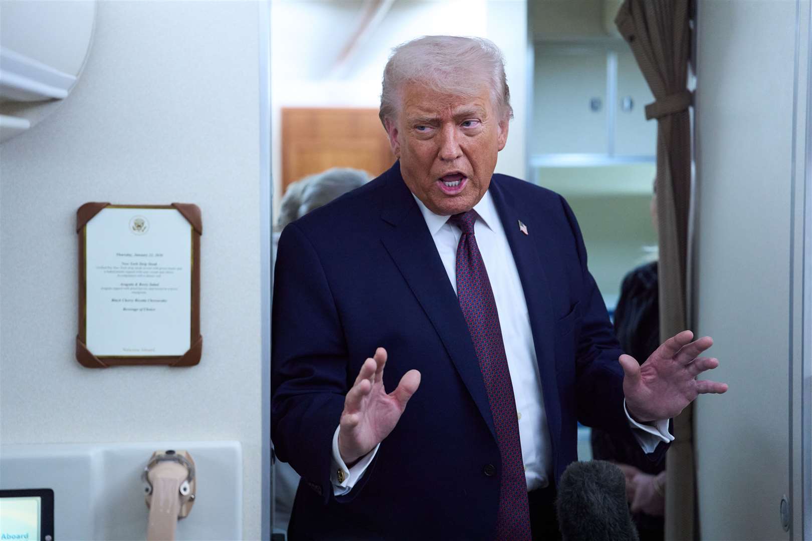 President Donald Trump speaks to reporters aboard Air Force One after leaving the World Economic Forum in Davos for Washington (Evan Vucci/AP)