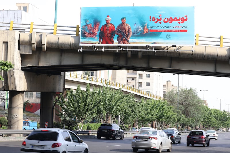 An anti-US banner that reads in Persian, 'Our cannons are full' and referring to the Strait of Hormuz, is placed across a bridge spanning a highway in Tehran, Iran, on May 12th, 2026. Photograph: Atta Kenare/AFP/Getty