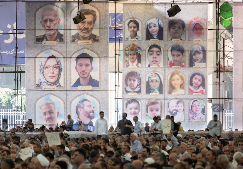 Iranian worshippers sit under banners featuring portraits of people killed in Israeli attacks, in Tehran on Friday. Photograph: Morteza Nikoubazl/NurPhoto via Getty Images