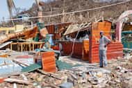 A man stands next to a business destroyed by Hurricane Beryl in Clifton, Union Island, St....