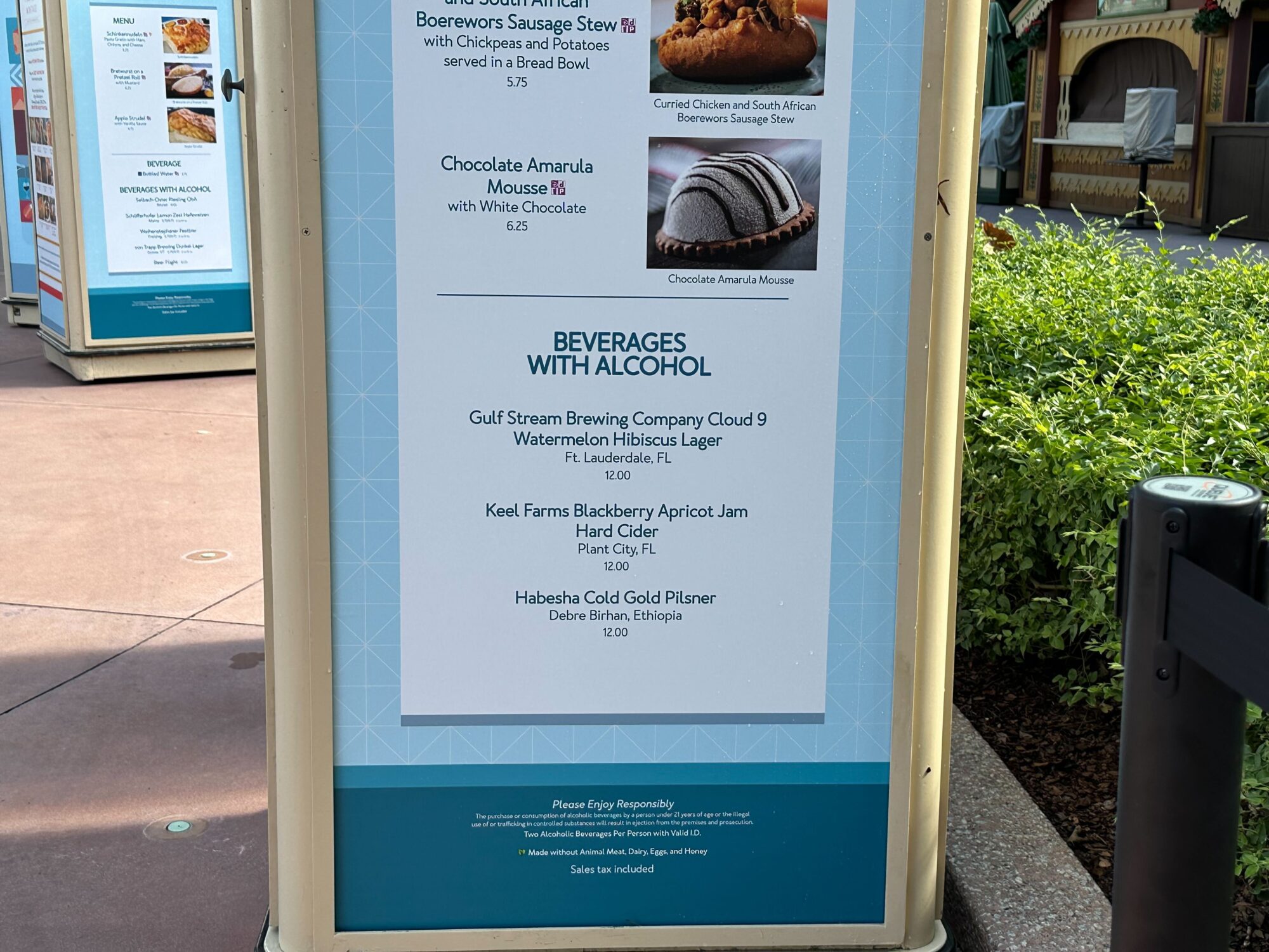 Menus (With Prices) for 2024 EPCOT International Food & Wine Festival 27 Menu board displaying a list of beverages with alcohol including beers and a hard cider, located in an outdoor setting.