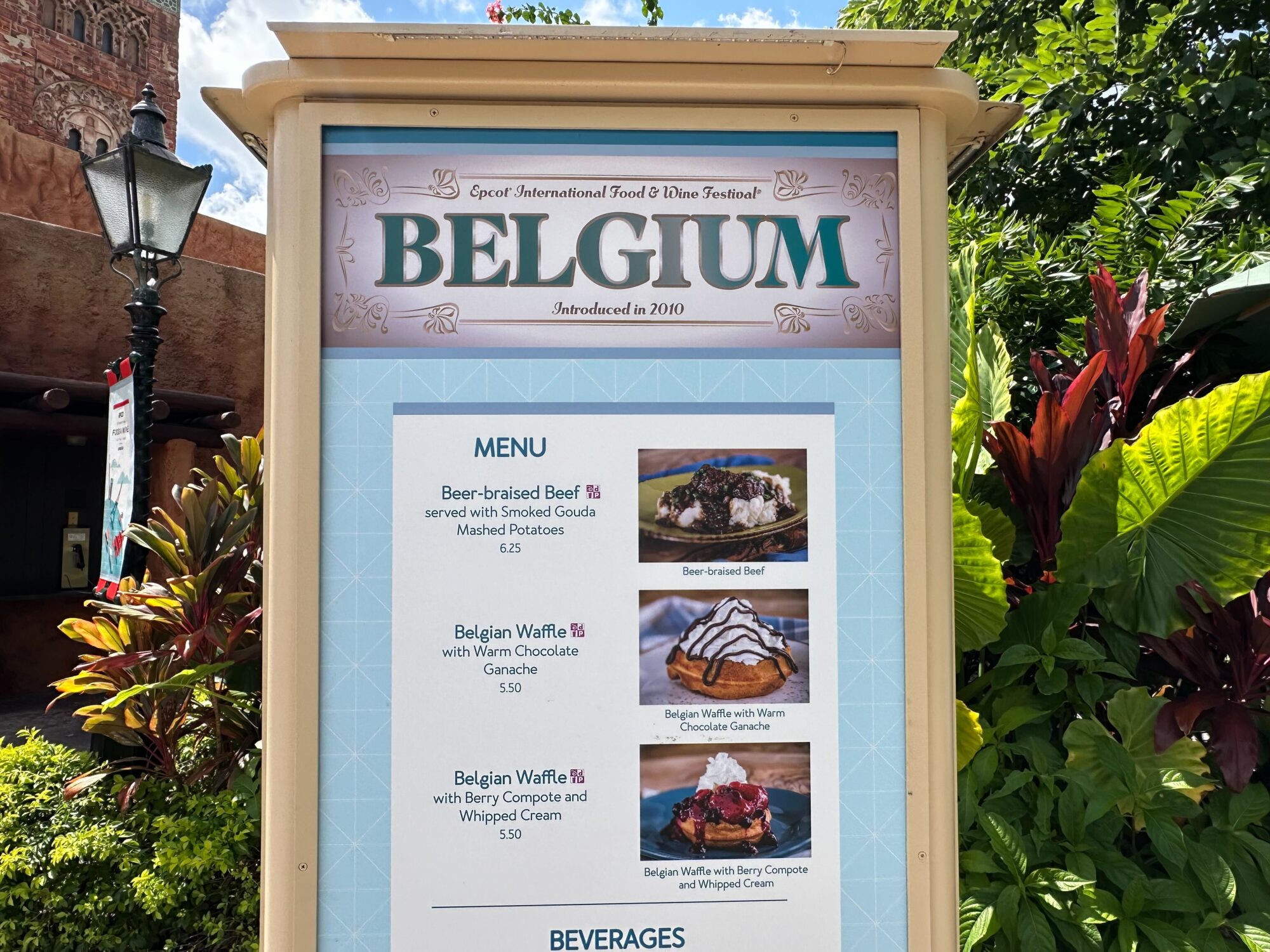 Menus (With Prices) for 2024 EPCOT International Food & Wine Festival 48 Sign for the Belgium booth at the food & wine festival, featuring menus that include beer-braised beef, Belgian waffles with various toppings, and a selection of beverages.