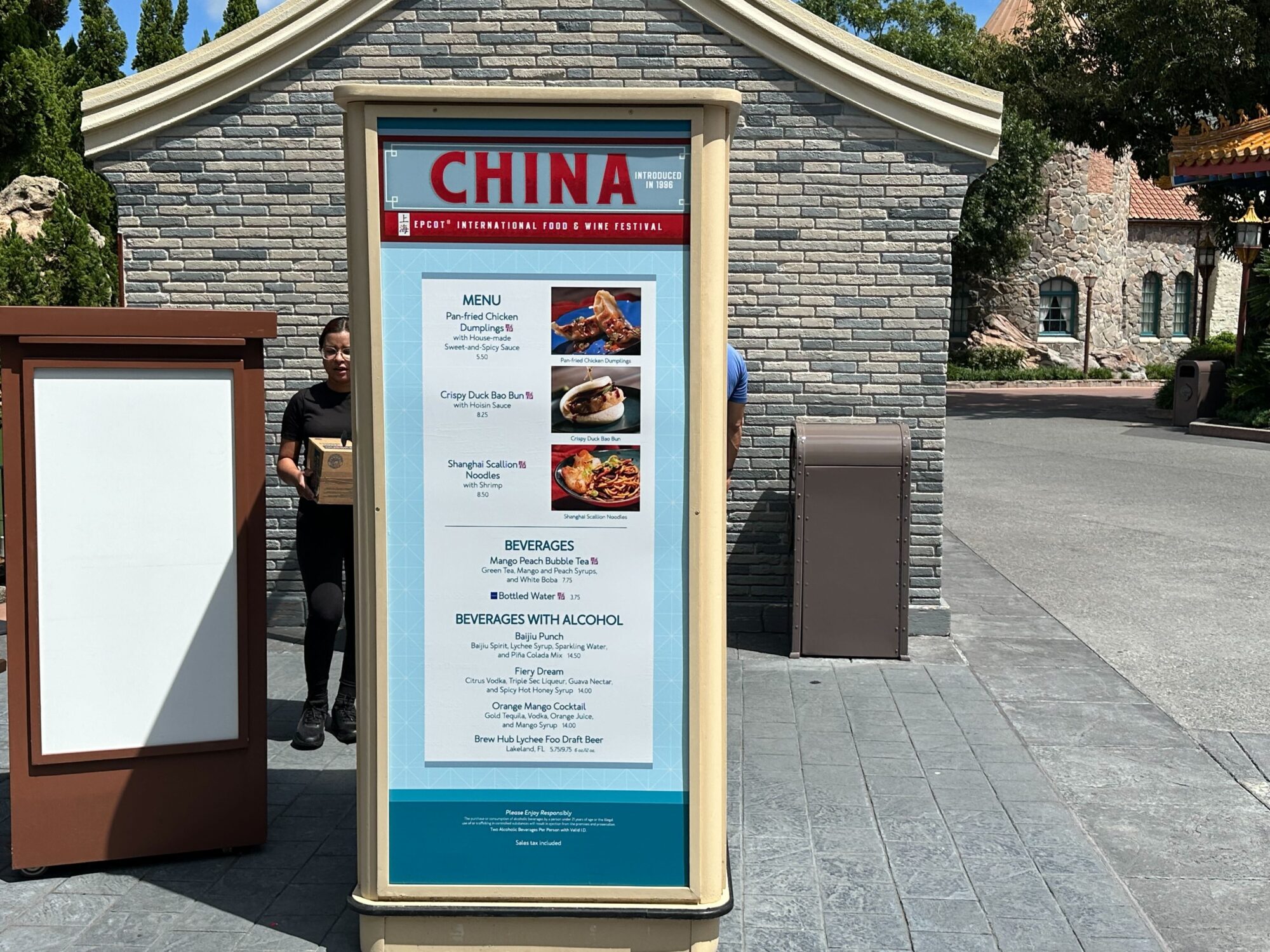 Menus (With Prices) for 2024 EPCOT International Food & Wine Festival 19 Menu board for the China kiosk at an international food & wine festival, featuring dishes like Pot-Stickers and beverages including BaiJoe Punch and Jasmine Draft Beer. Browse our menus to find your favorites. A trash bin is located nearby.