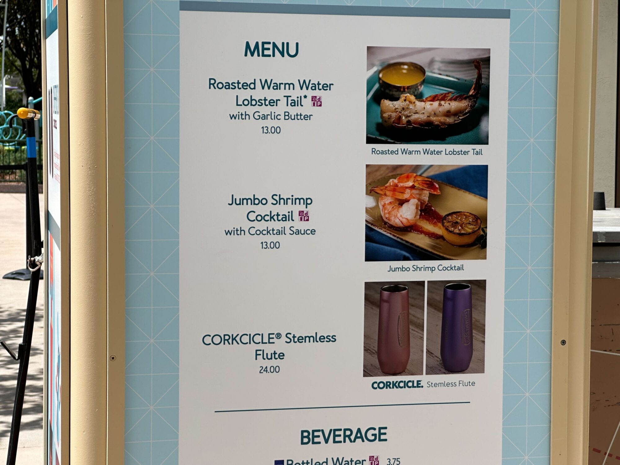 Menus (With Prices) for 2024 EPCOT International Food & Wine Festival 5 A menu featuring roasted warm water lobster tail with garlic butter for $13, jumbo shrimp cocktail with cocktail sauce for $13, and Corkcicle stemless flutes for $24, along with beverages. Perfect for a food & wine festival.