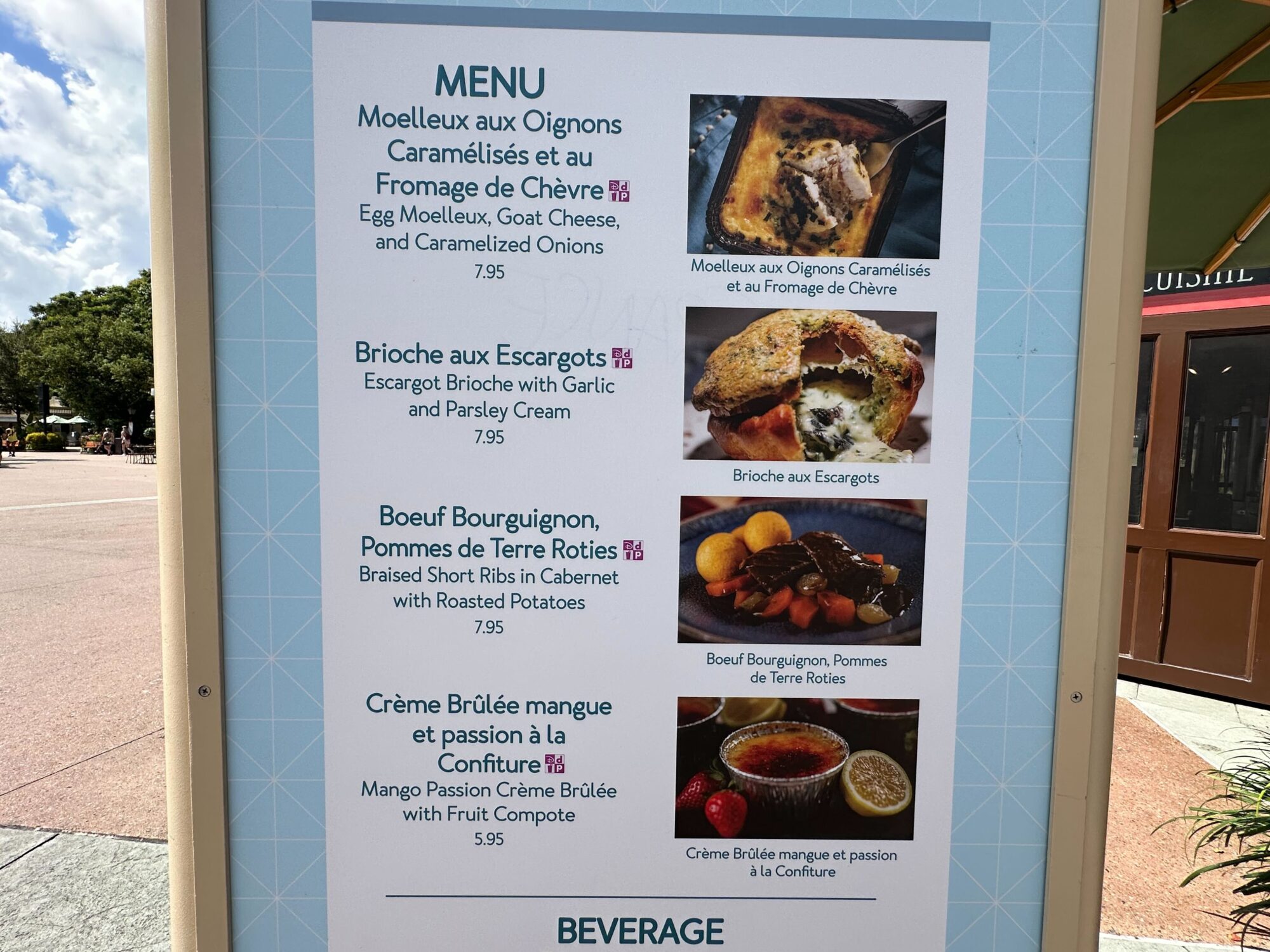 Menus (With Prices) for 2024 EPCOT International Food & Wine Festival 54 A menu board at the food & wine festival features delectable items like Egg Moelleux, Brioche aux Escargots, Boeuf Bourguignon, and Crème Brûlée, all displayed with enticing images and prices.