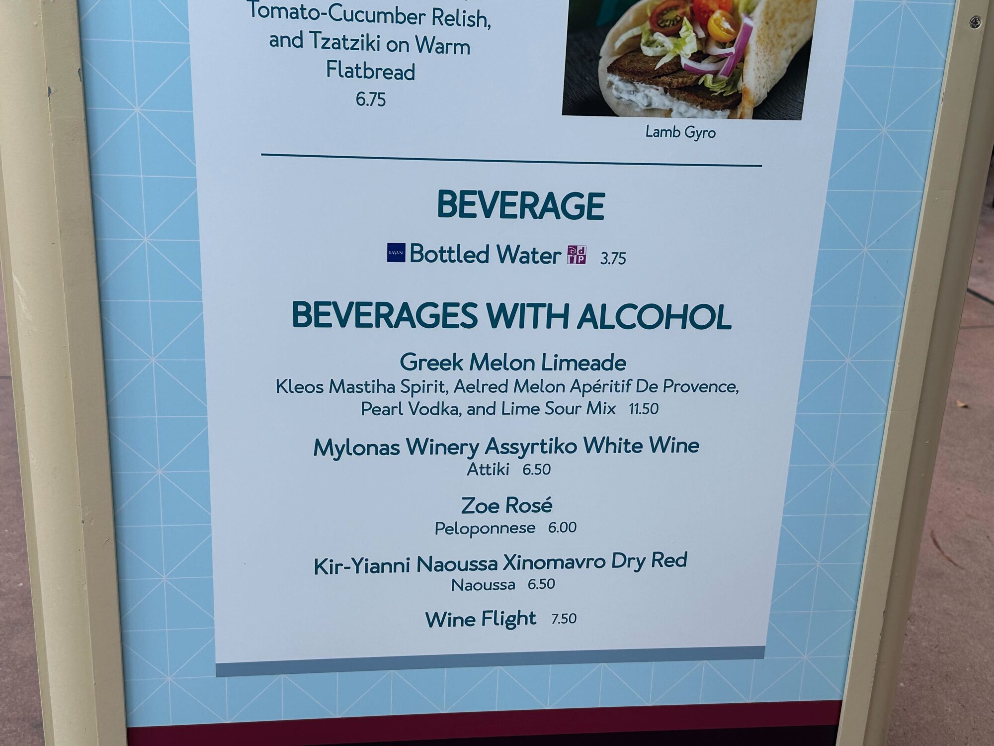 Menus (With Prices) for 2024 EPCOT International Food & Wine Festival 45 A menu displays beverage options, including bottled water and alcoholic drinks: Greek Melon Limeade, Mylonas Winery Assyrtiko White Wine, Zoe Rosé, Kir-Yianni Naoussa Xinomavro Dry Red, and Wine Flight. Perfect for any food & wine festival!