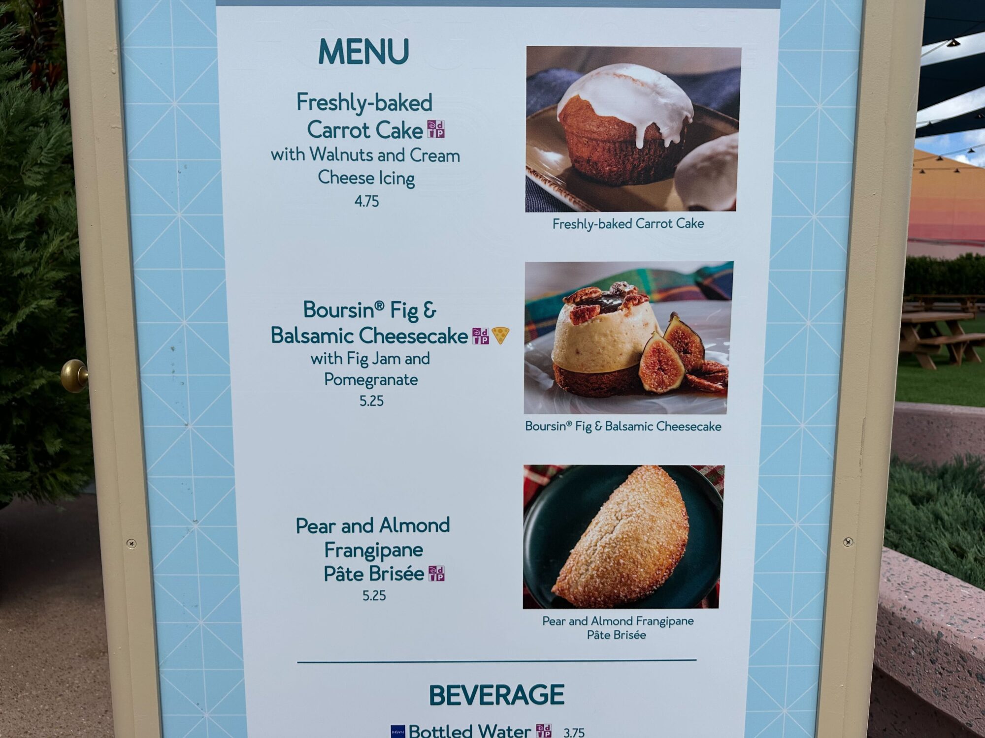 Menus (With Prices) for 2024 EPCOT International Food & Wine Festival 68 Menu board for our food & wine festival displaying three desserts: Freshly-baked Carrot Cake ($4.75); Boursin Fig & Balsamic Cheesecake ($5.25); Pear and Almond Frangipane Pâte Brisée ($5.75). Bottled water is $3.75.