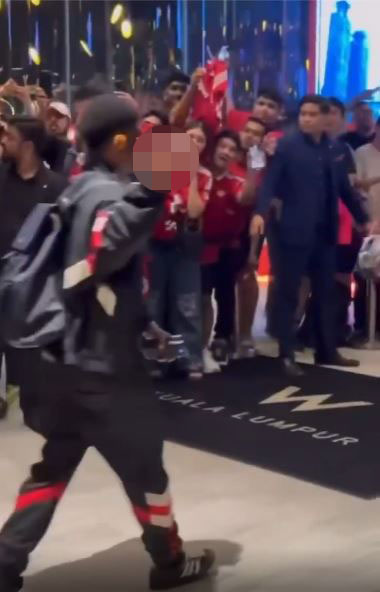 Amad Diallo and other Manchester United players walking past fans in Kuala Lumpur.