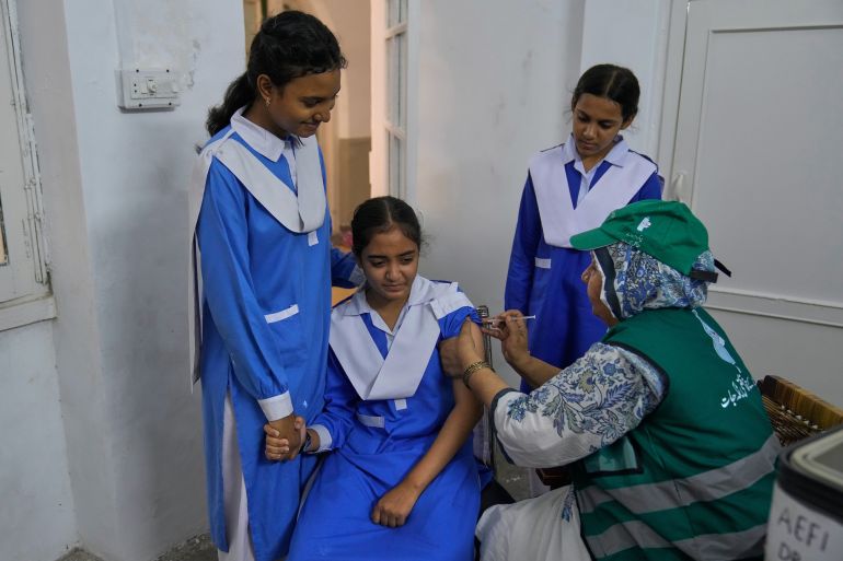 A health worker gives an injection of human papillomavirus (HPV) vaccine to a girl during a campaign aiming to protect girls from cervical cancer, at a school in Lahore, Pakistan, Monday, Sept. 22, 2025. (AP Photo/K.M. Chaudary)