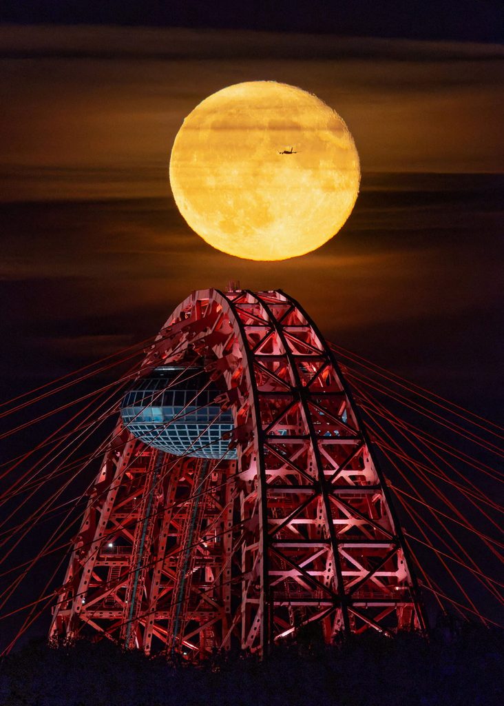 The full moon rises over a bridge in Moscow