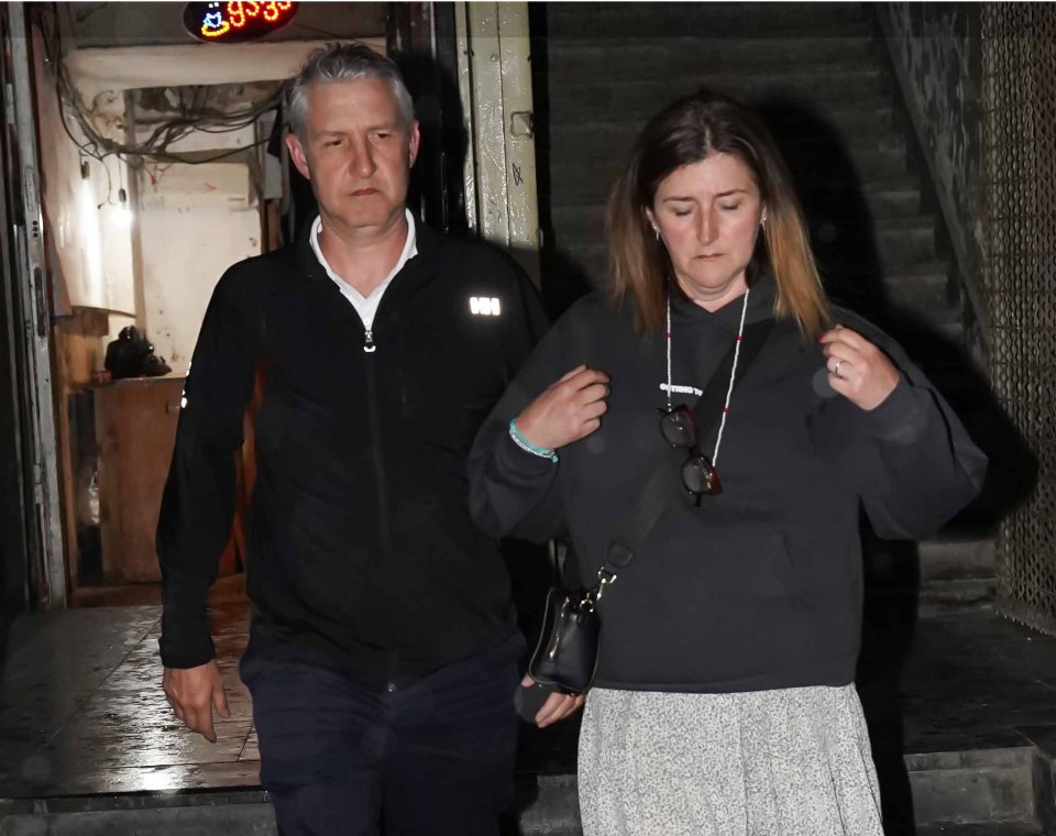 A man and woman leaving a building.