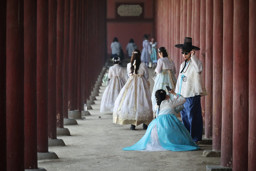A couple wearing Korean traditional costume Hanbok shares a moment at Gyeongbokgung palace in Seoul