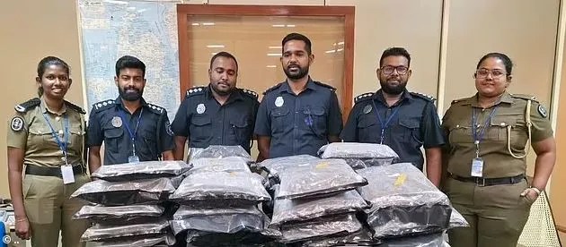 Police officers posing with confiscated drugs.