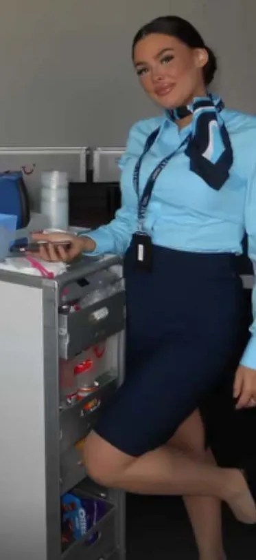 Flight attendant stocking beverage cart.